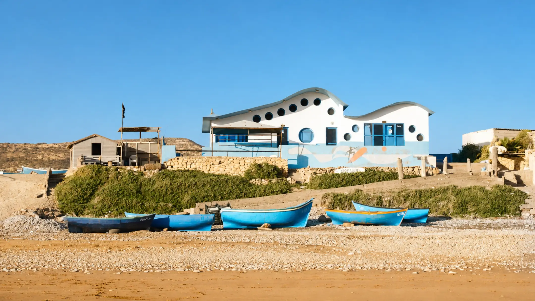 Coastal building and fishing boats at Devil's Rock in Tamraght, Morocco
