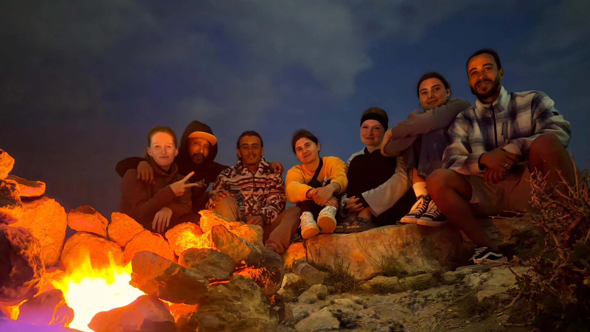Group gathered around a fire outdoors at night