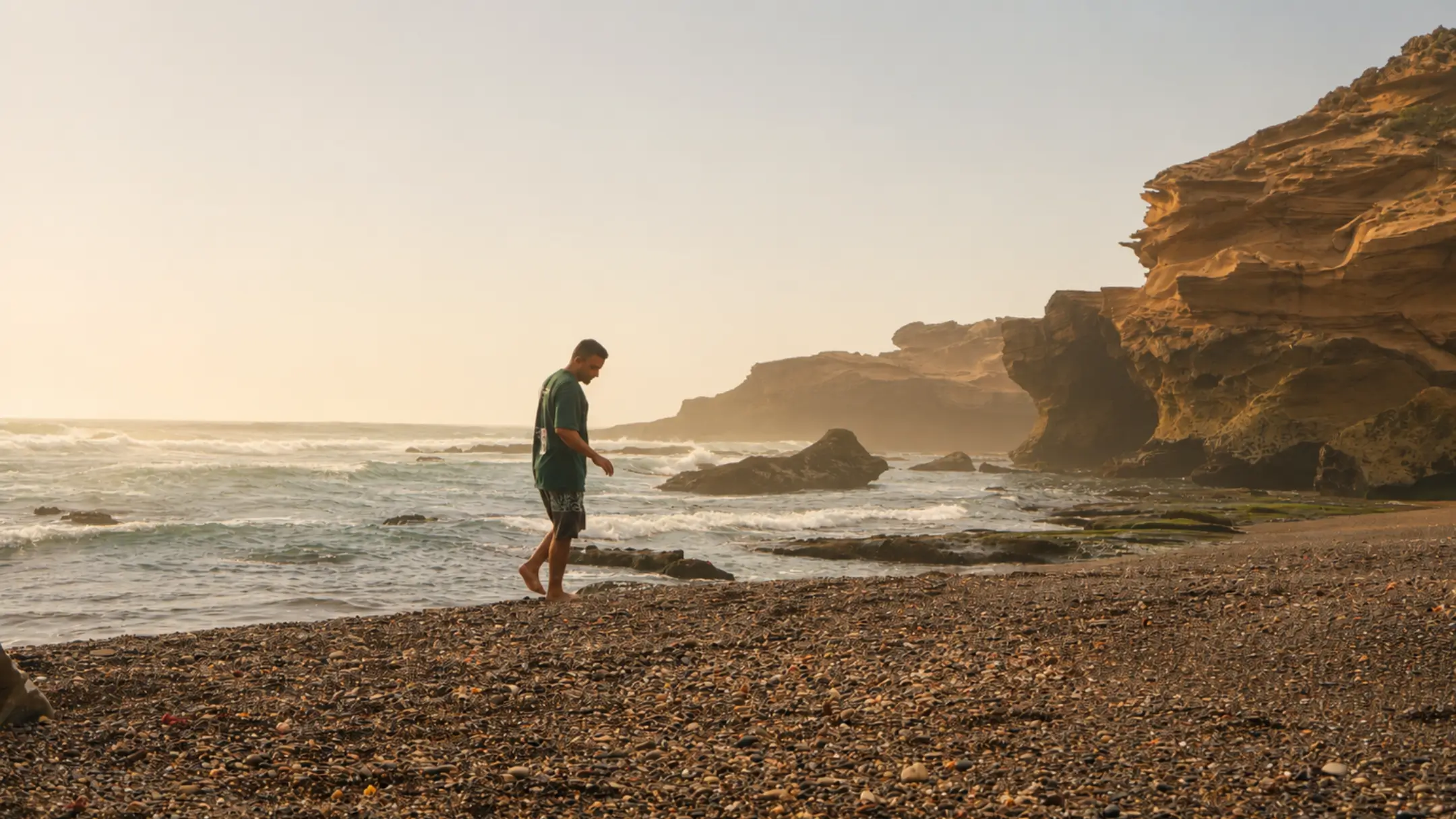 Person walking barefoot along a quiet Atlantic beach during a coastal holiday