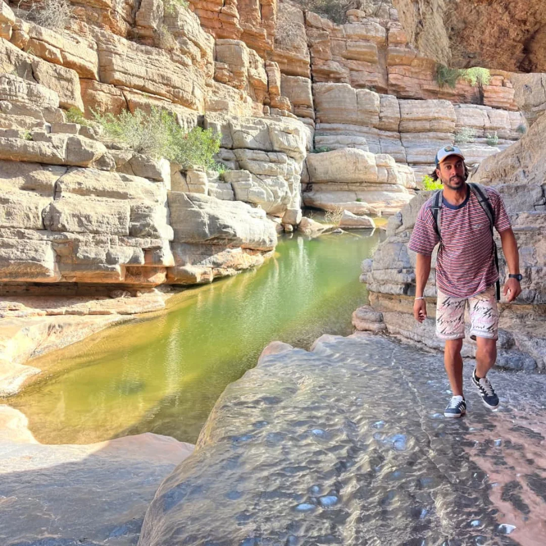 Walk beside a natural pool surrounded by rocky cliffs