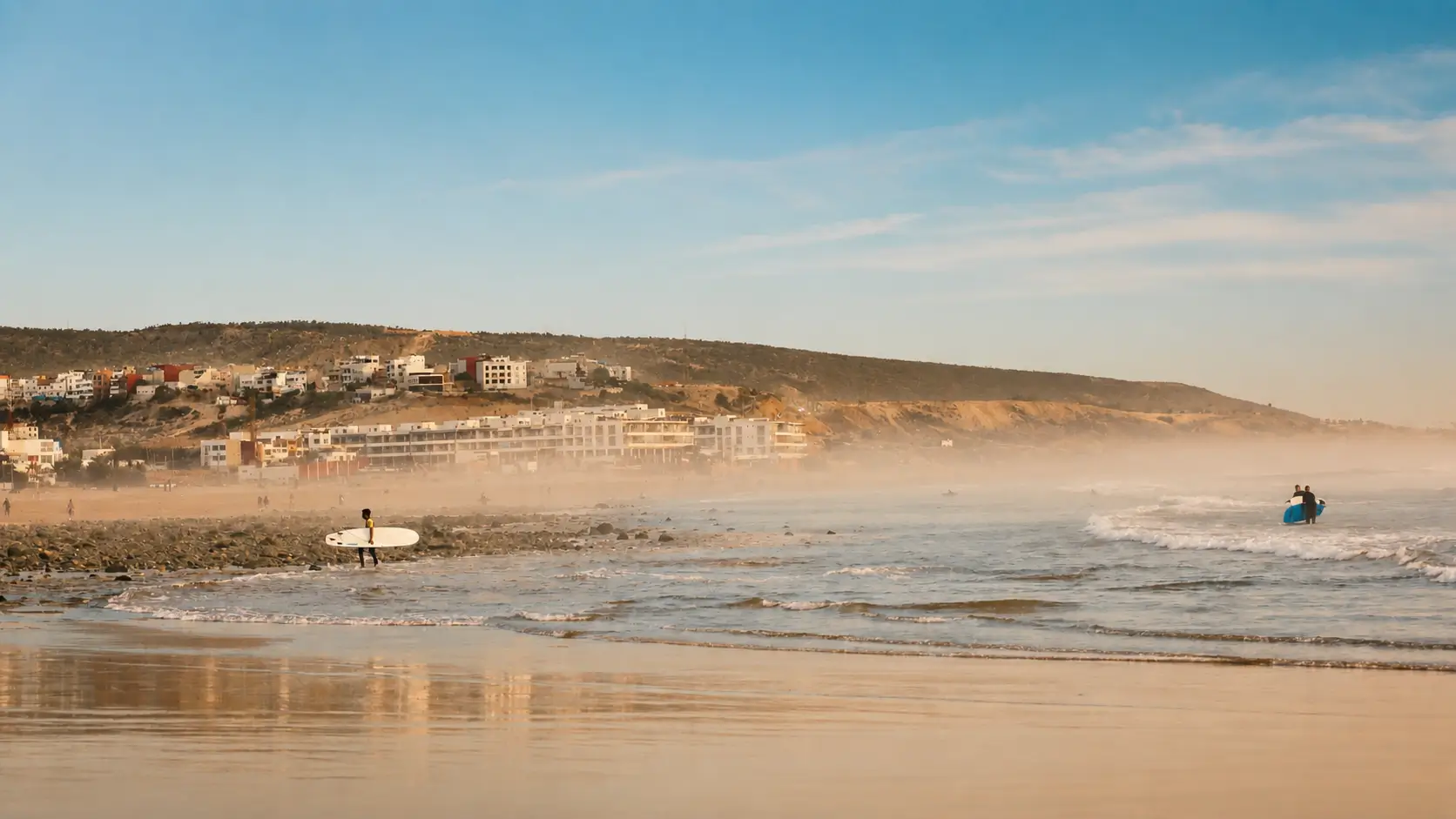 Surfers walking along the Atlantic coast in Morocco