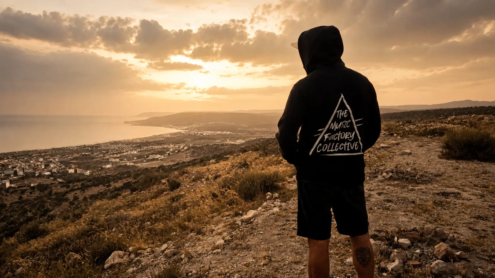 Person overlooking the coastline during a quiet sunset