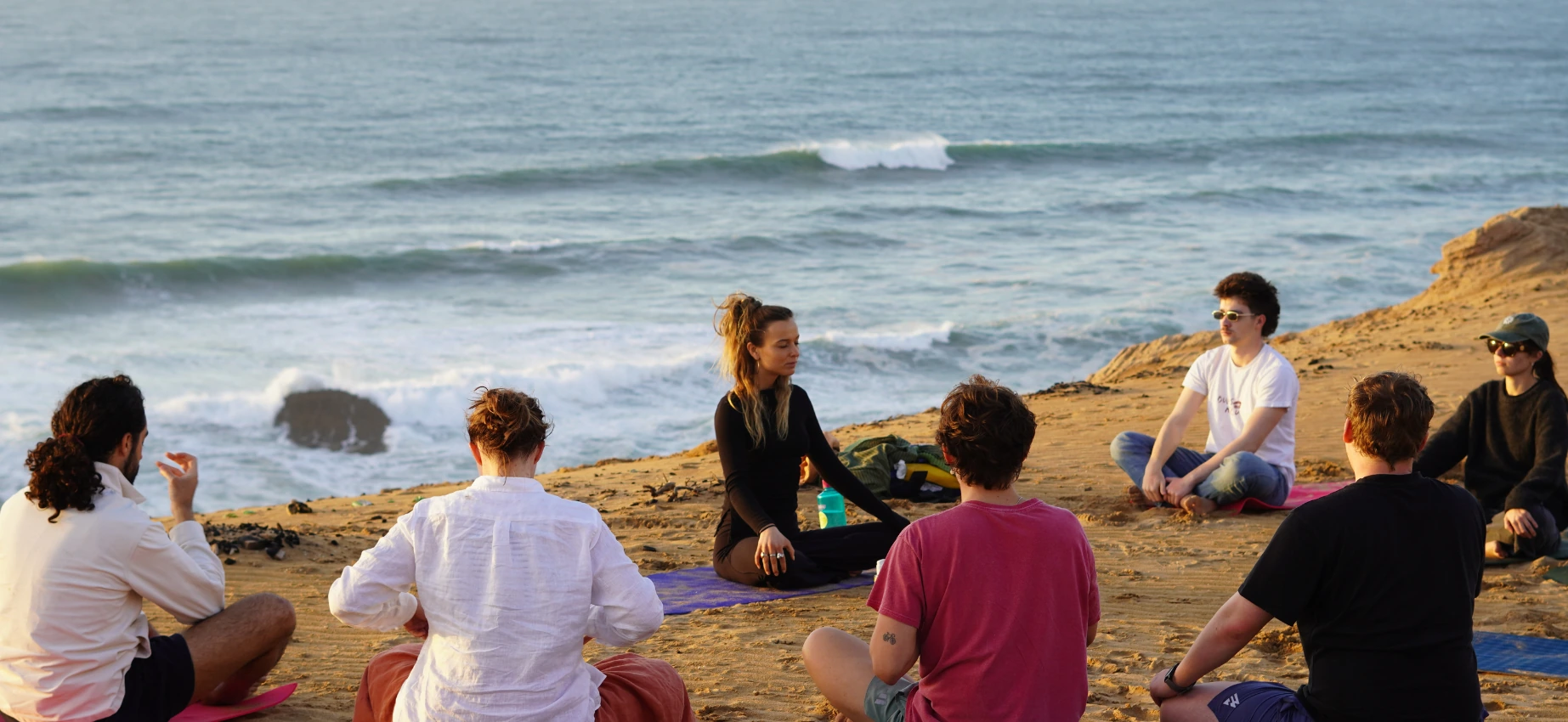 Group yoga session overlooking the ocean at sunset
