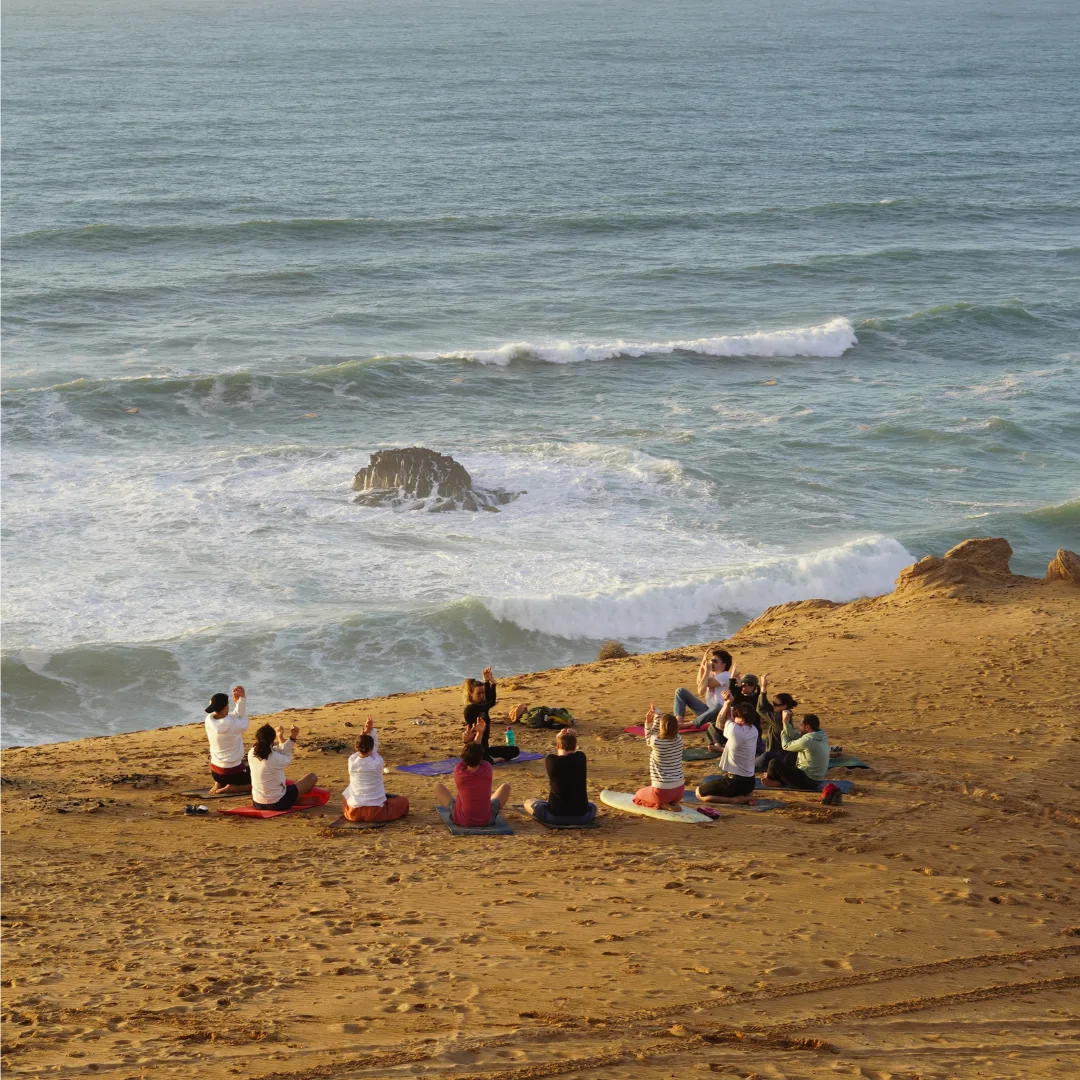 Group yoga session overlooking the ocean at sunset