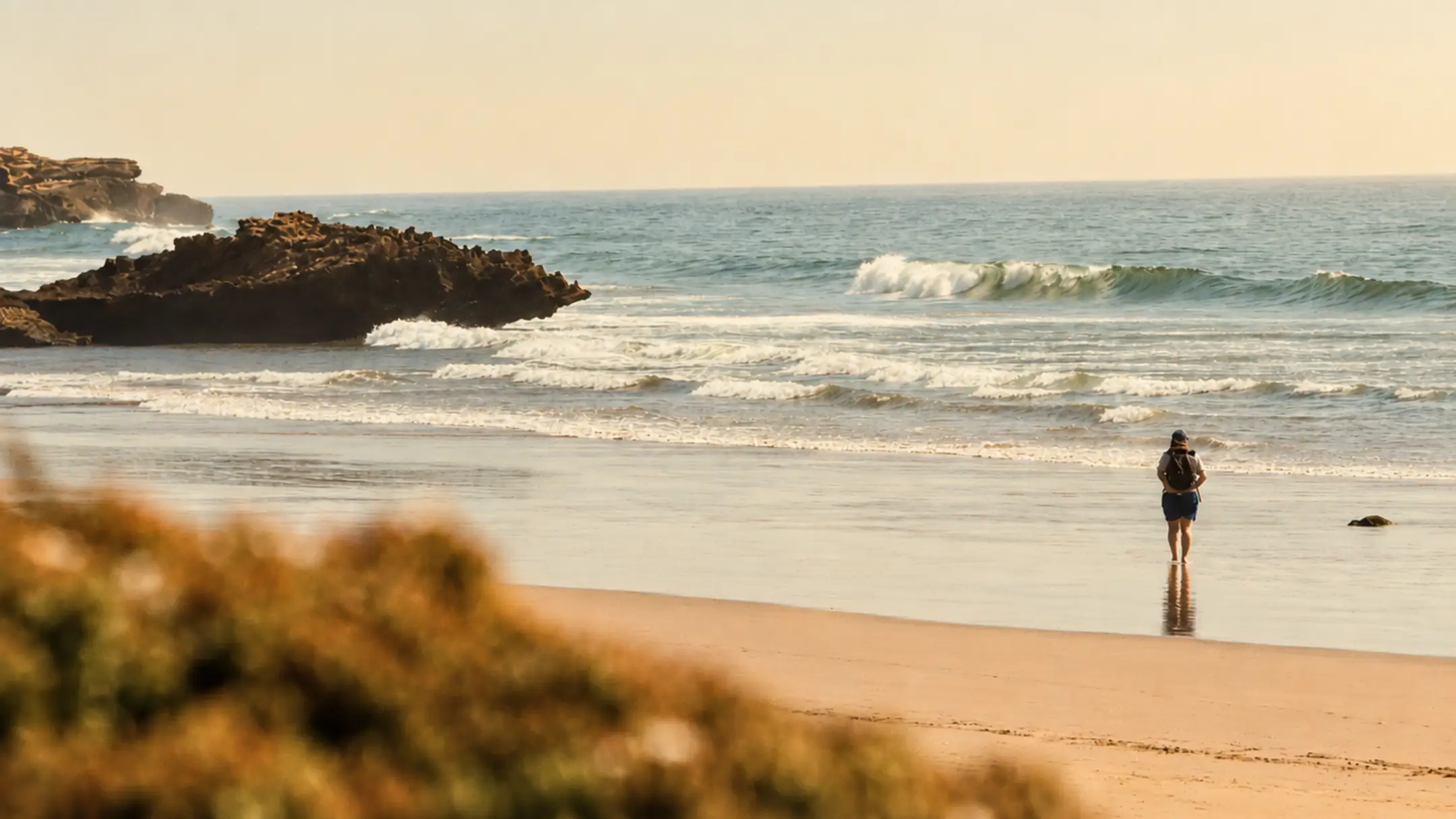 Person standing quietly at the shoreline watching waves on Morocco's Atlantic coast