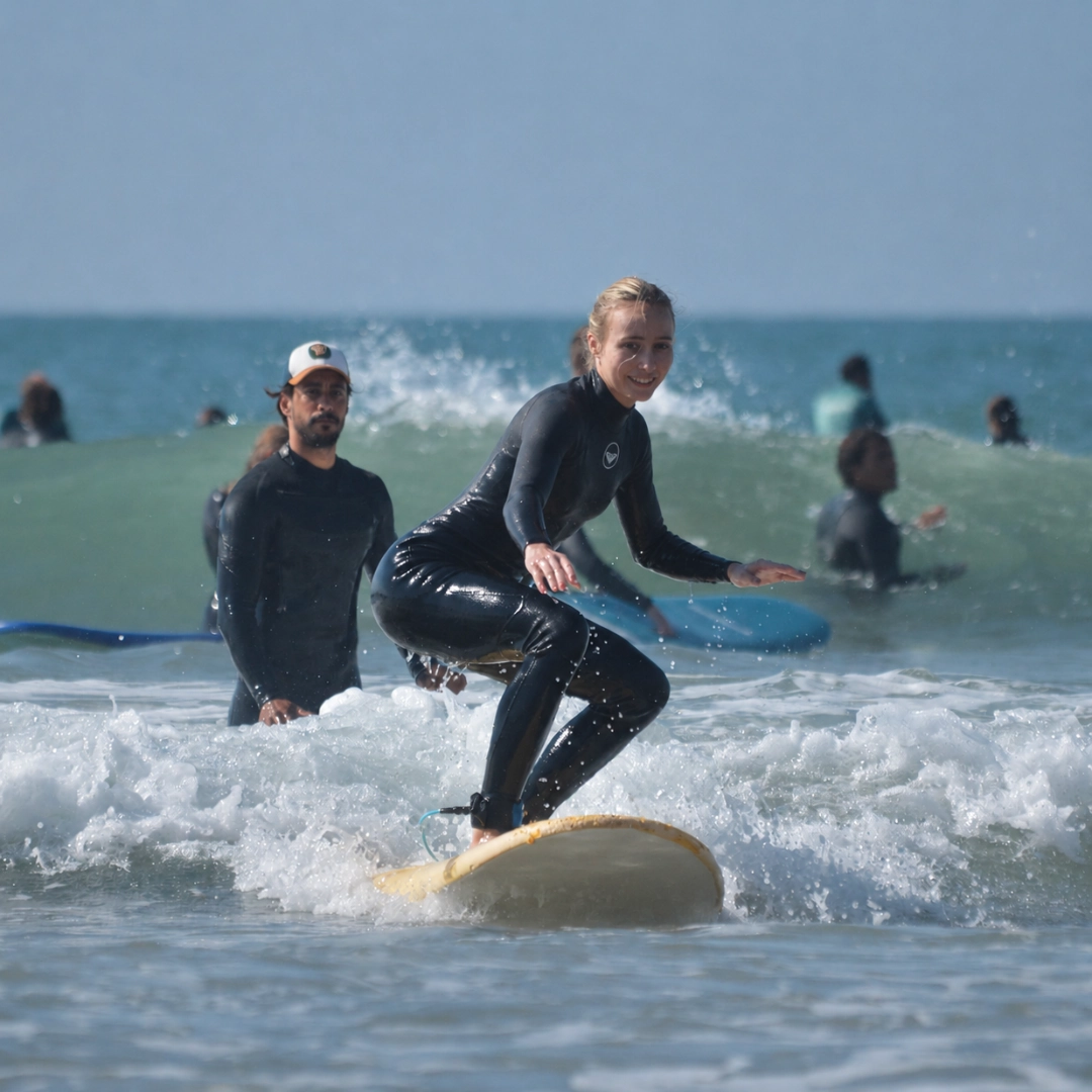 Group of surfers standing in shallow water with surfboards