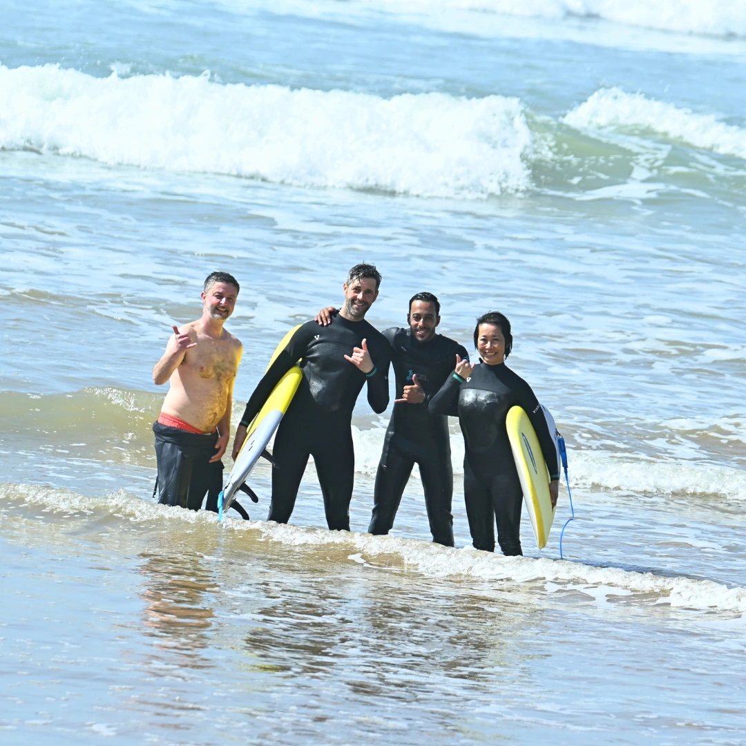 Surfer paddling through white water with another surfer behind