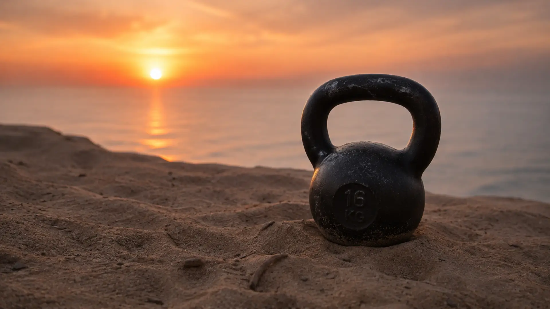 Kettlebell on the sand overlooking the ocean at sunset